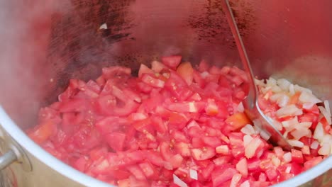slow-motion-of-Kosher-military-food-pot-with-onions-and-tomatoes-frying-in-the-oil-while-mixed