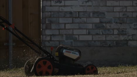 A-lithium-battery-operated-lawn-mower-being-pushed-over-lawn-in-back-yard