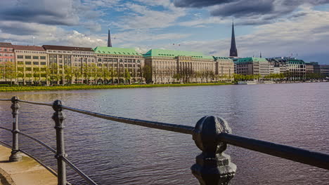 Hyperlapse-shot-of-Hamburg-Alster-Lake-with-fountain-and-beautiful-historic-buildings-on-shore-during-cloudy-day---Hamburg,Germany