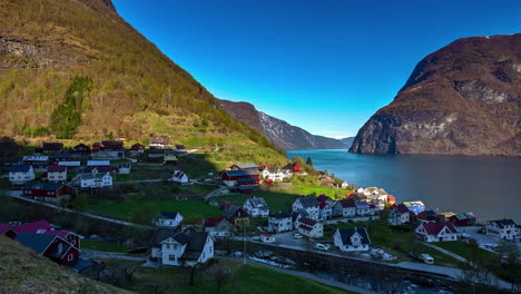 Beautiful-overview-of-a-Norwegian-fishing-village-in-Lofoten,-Norway-surrounded-by-mountain-range-and-beside-a-lake-in-sunset-timelapse