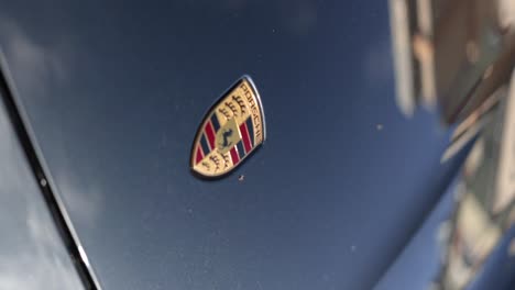 Vertical-close-up-shot-of-famous-top-quality-car-symbol-design-on-a-brand-new-electrical-vehicle