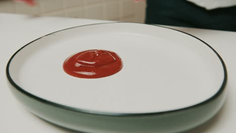 Putting-delicious-red-ketchup-onto-big-plate