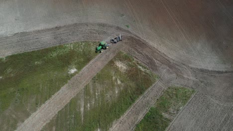 A-tractor-plowing-a-field-to-plant-soybeans-in-the-Brazilian-Savannah---straight-down-aerial-view