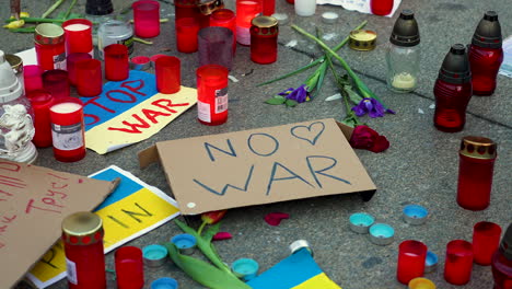 Antiwar-sign,-ukrainian-flags-and-candles-on-the-pavement-at-a-protest