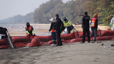 Oil-Spill-In-Rayong,-Thailand---Navy-And-SPRC-Workers-In-Protective-Suits-Used-Inflatable-Oil-Boom-During-Clean-up-Operations-In-Mae-Ram-Phueng-Beach