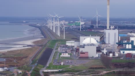 EPZ-nuclear-power-plant-facility-with-spinning-wind-turbines-in-background