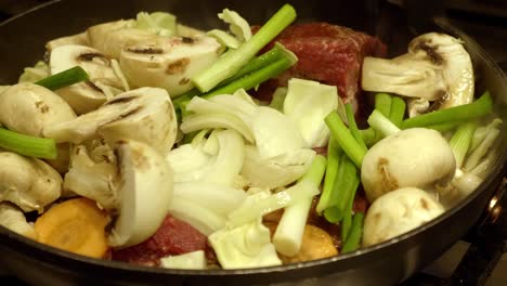 PersonTossing-Fresh-Ingredients-Of-Korean-Stew-In-A-Big-Pot---close-up-shot