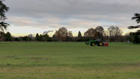 A-tractor-trims-the-grass-on-a-football-pitch-in-Bury-St-Edmunds,-Suffolk