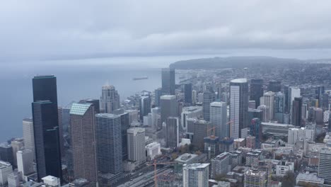 Drone-shot-pulling-away-from-Seattle's-downtown-sector-on-a-cloudy-day