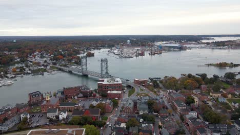 Aerial-view-overlooking-the-Piscataqua-river-and-the-cityscape-of-cloudy-Portsmouth-city---pan,-drone-shot
