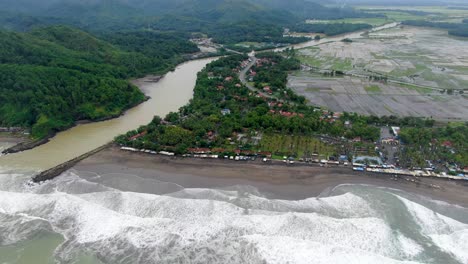 Aerial-drone-view-of-Telomoyo-River-and-surrounding-landscape-near-Suwuk-beach-in-Kebumen,-Indonesia