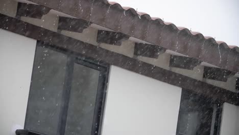 Rain-falling-in-the-roof-of-a-house-in-a-suburban-setting---Slowmotion