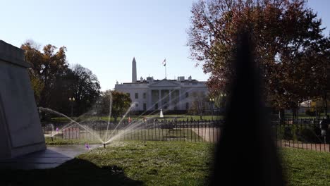 Establishing-shot-The-White-House-in-distance,-view-of-watering-system-on-beautiful-garden