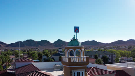 Ein-Taubenschwarm-Fliegt-Um-Einen-Kleinen-Turm-In-Beatty,-Nevada