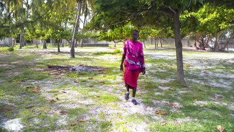 African-maasai-man-in-traditional-clothing-walking-in-palm-grove