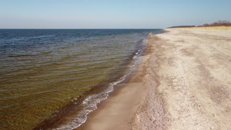 Luftaufnahme-Von-Meereswellen,-Die-An-Einem-Sonnigen-Frühlingstag-In-Den-Strand-Mit-Weißem-Sand-Schlagen,-Ostsee,-Pape-Beach,-Lettland,-Aufsteigende-Weitwinkel-drohnenaufnahme
