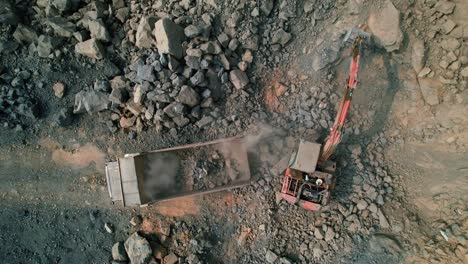 Aerial-drone-shot-of-excavator-loading-rocks-in-truck