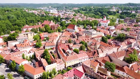 Red-and-green-colors-of-Vilnius-old-town-on-sunny-day,-aerial-fly-backward