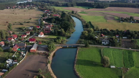 Aerial-rural-shot-of-a-small-village-and-farms-by-the-river