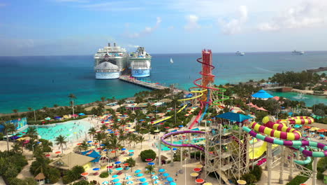 Wide-rotating-drone-shot-of-CoCoCay-island-with-water-slides-and-a-Royal-Caribbean-cruise-ship-in-the-background