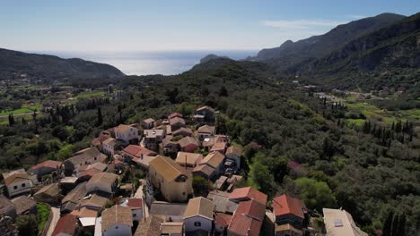 Forward-droneshot-over-isolated-village-on-top-of-green-mountain-in-Greece