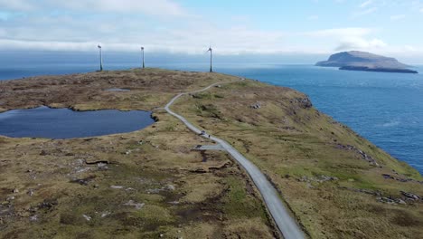 Weißer-Wohnmobil,-Der-Auf-Einer-Malerischen-Straße-Zwischen-Windkraftanlagen-Auf-Den-Färöer-Inseln-Fährt