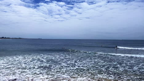 Quick-Pan-view-of-surfers-and-swimmers-at-Moffat-Beach,-Sunshine-Coast-Queensland-Aus