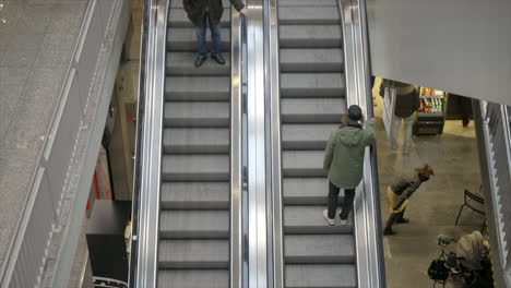 A-man-in-a-green-jacket-rides-up-an-escalator