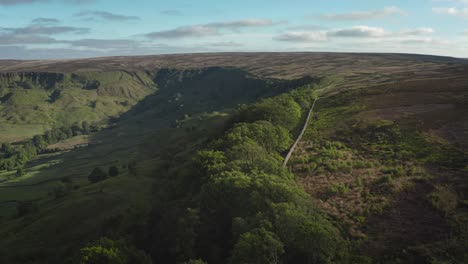 Low-level-drone-shot,-moving-out-sideways-over-steep-rocky-and-wooded-slope-at-Fryupdale-in-the-North-York-Moors