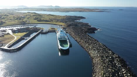 LNG-powered-ferry-Raunefjord-alongside-at-Mortavika-Norway---Beautiful-sunny-day-aerial-with-reflections-in-sea-surface