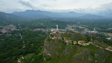 Aerial-of-a-Jesus-Christ-Statue-in-Tana-Toraja-Sulawesi-at-the-top-of-a-mountain-with-tourists-and-shops