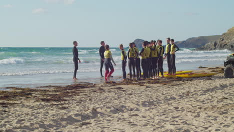 Eine-Gruppe-Junger-Teenager-Versammelte-Sich-Am-Strand-Von-Perranporth-Und-übte-Mit-Ihrem-Lehrer,-Wie-Man-Menschen-Auf-See-In-Cornwall-Rettet