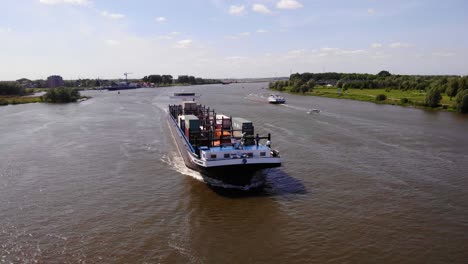 Drone-Shot-Over-Oude-Maas-With-Missouri-Cargo-Ship-Navigating-Along-In-Zwijndrecht