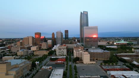 Aerial-view-towards-high-rise-in-sunset-lit-Oklahoma-city-downtown---approaching,-drone-shot