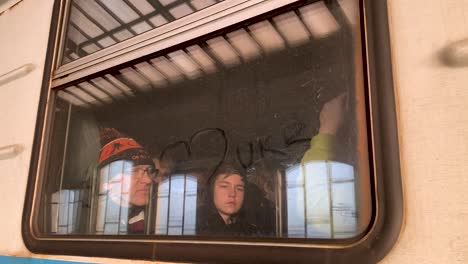 The-symbol-of-a-heart-is-drawn-on-the-dust-of-a-train-window---train-full-of-Ukrainian-refugees-escaping-the-war-with-Russia