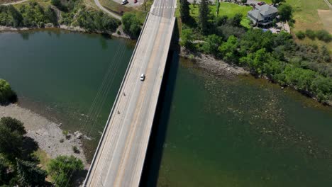 Top-down-view-of-a-car-driving-over-a-bridge-that-crosses-the-Spokane-River