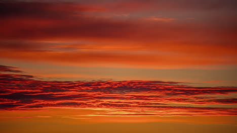 Time-lapse-shot-of-cirrostratus-clouds-slowly-flying-at-orange-colored-sky-during-sunset-time