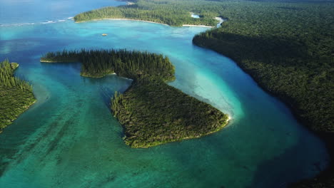 Slow-aerial-tilt-up-revealing-horizon,-small-islands-of-Oro-Bay,-Isle-of-Pines