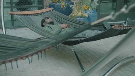 A-man-relaxes-on-a-hammock-in-the-middle-of-the-day