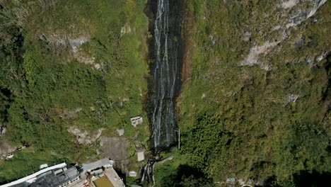 Fly-Away-At-Virgin-Waterfalls-Flowing-Down-From-Sheer-Mountains-In-Baños,-Ecuador