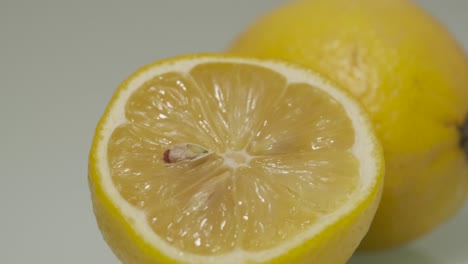 Juicy-fresh-cut-lemon-with-yellow-peel-and-white-rind-panning-from-right-to-left-with-rotating-ambience-lighting