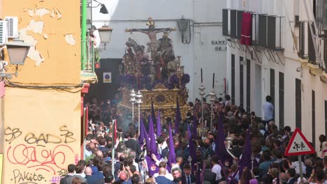 Penitents-carry-the-image-of-Jesus-Christ-through-worshippers-crowds-during-a-Holy-Week-procession-in-Seville,-Spain