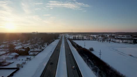Drone-view-of-beautiful-snowy-highway-in-the-evening-sunset