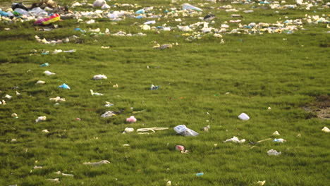 Pradera-Natural-Verde-Contaminada-Con-Bolsas-De-Plástico-Y-Residuos-De-Botellas,-Entorno-Natural-Desolado-Vertedero-Rural