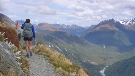 Excursionista-Camina-Estática,-Pista-Alpina-Ventosa-Expuesta,-Valles-Distantes,-Routeburn-Track-Nueva-Zelanda