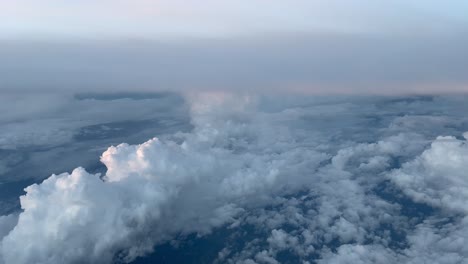 COCKPIT-VIEW,-DAWN--High-altitude-cruising-over-cumulonimbus-and-altocumulus-clouds