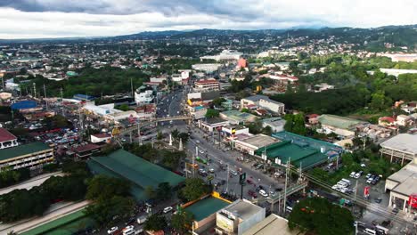 Aerial-view-of-traffic-intersection,-busy-highways-and-side-roads,-the-shot-of-huge-town-of-Rizal,-Philippines
