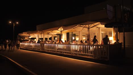 People-Dine-In-At-Italian-Restaurant-By-The-Canals-At-Night-In-Cesenatico,-Italy