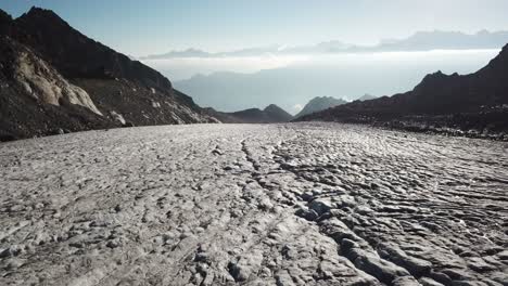 Langsames-Hineinschieben:-Großer-Gletscher-Mit-Gletscherspalten-In-Den-Schweizer-Alpen-Mit-Blick-Auf-Das-Tal-Und-Andere-Felsige-Berge,-Drohne
