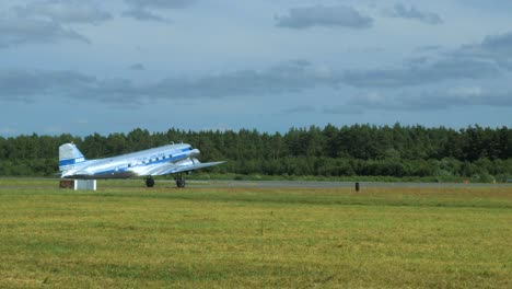 Silver-and-blue-Douglas-DC3-taxiing-out-to-the-runway-at-airshow,-side-view,-4k